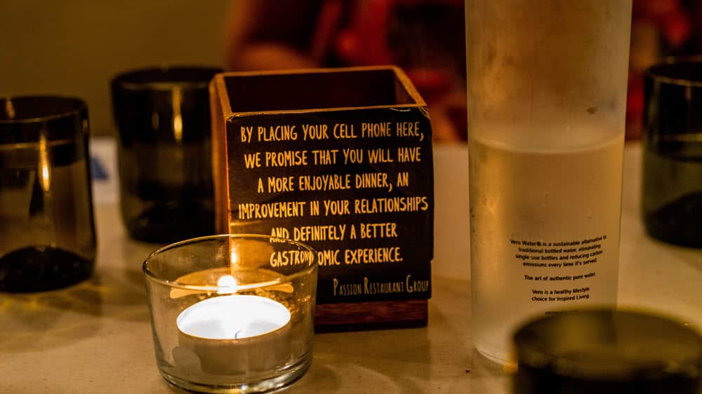 A brand taking a stand - tealight candle beside brown wooden box The cell phone rest box in Crazy About You restaurant. The box reads: By placing your cell phone here, we promise that you will have a more enjoyable dinner, an improvement in your relationships, and definitely a better gastronomic experience.